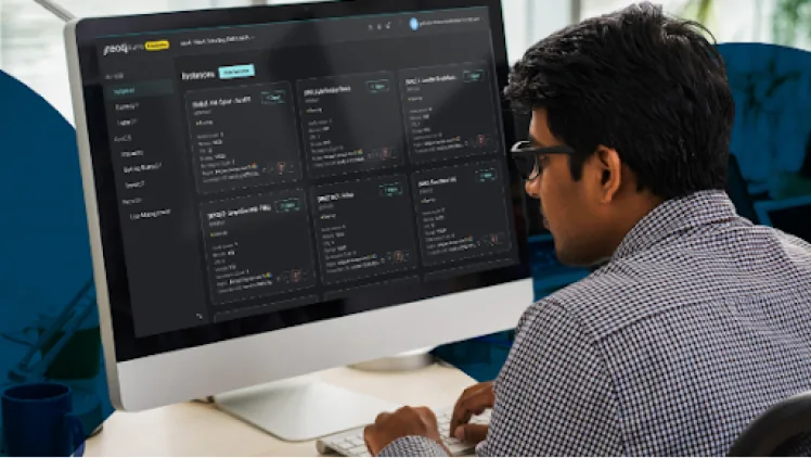 A person at a desktop monitor reviewing a Neo4j Aura database console